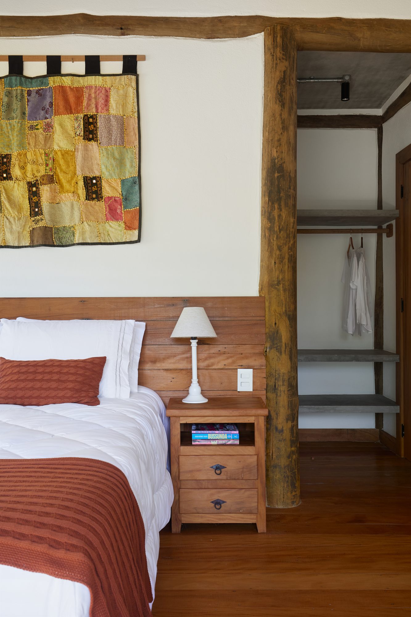 Quarto com painel de tecido colorido e manta terracota
