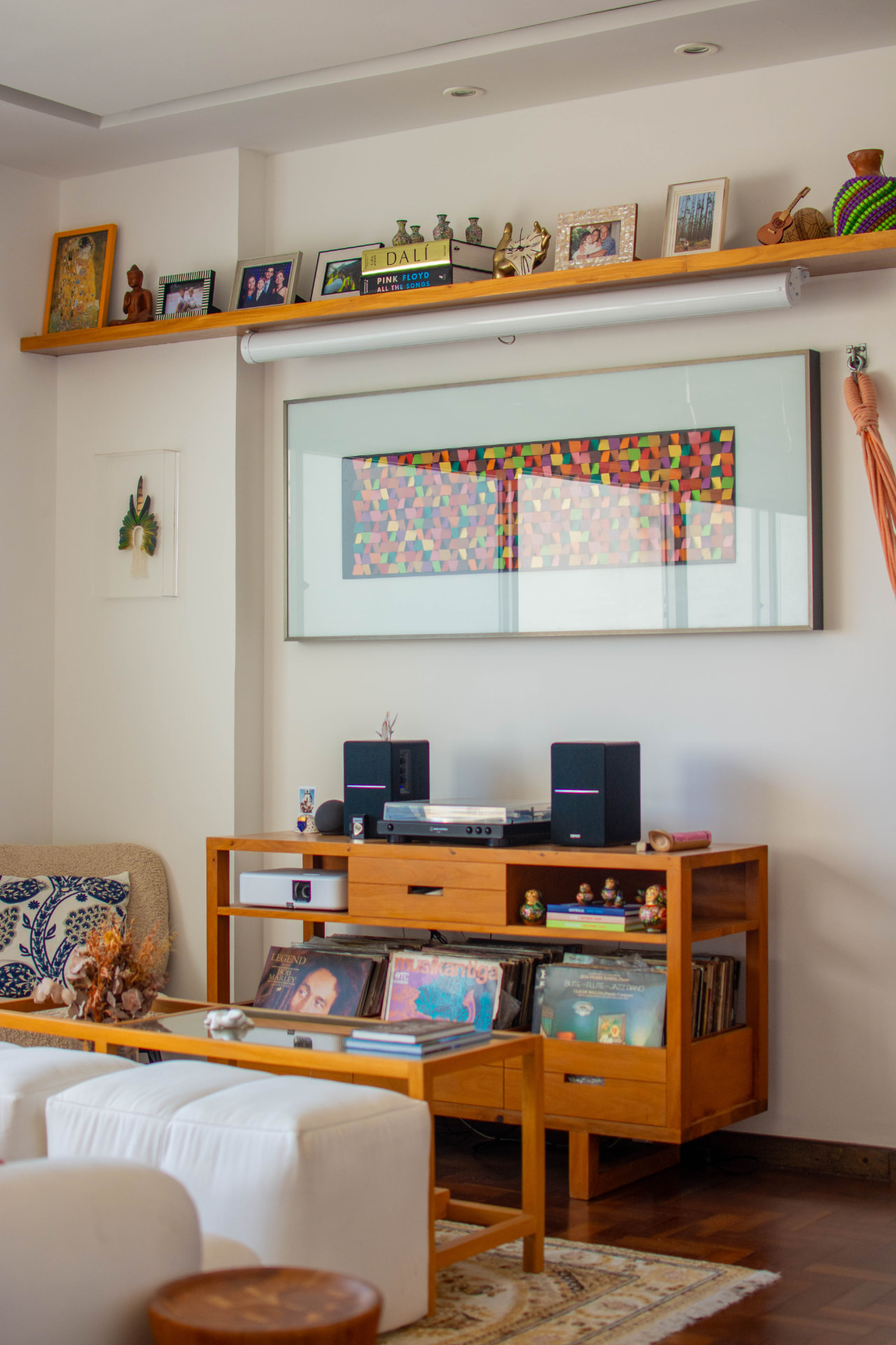 Sala de música com vitrola, coleção de discos e obra de arte colorida