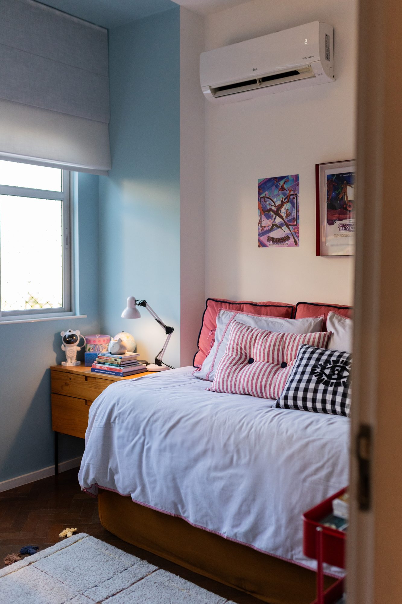 Quarto infantil com parede azul e almofadas coloridas