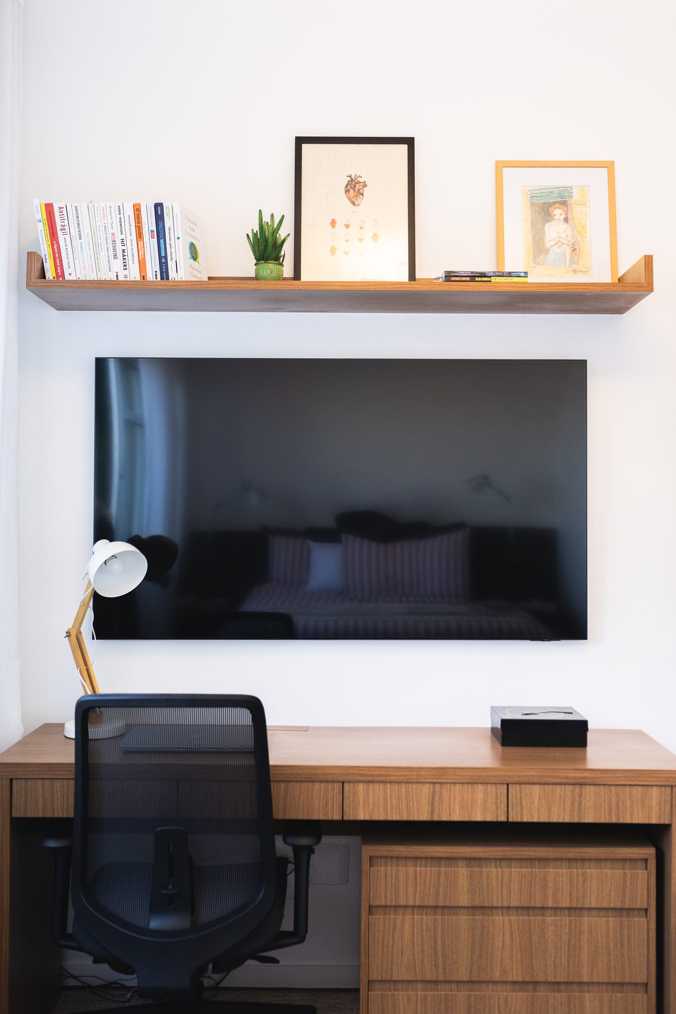 Home office com TV, prateleira e escrivaninha de madeira